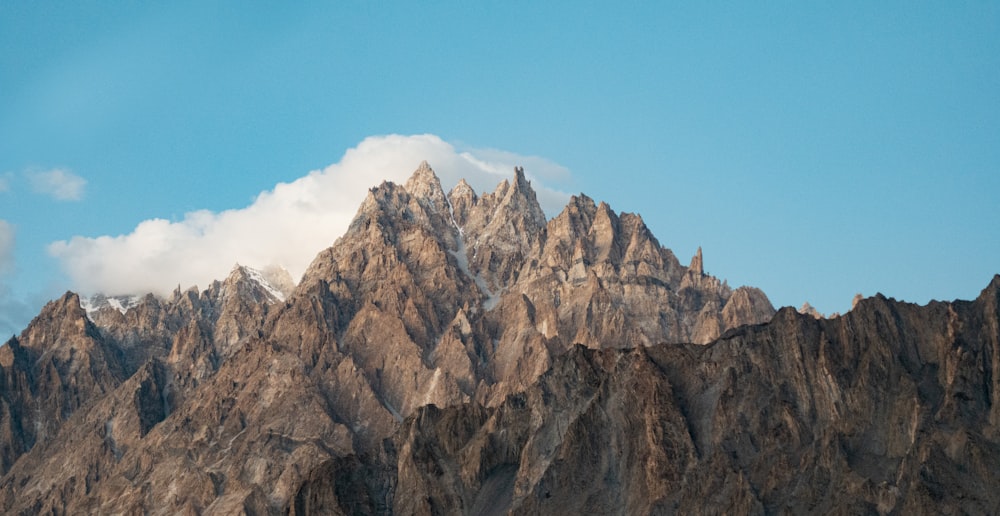 a very tall mountain with some clouds in the sky