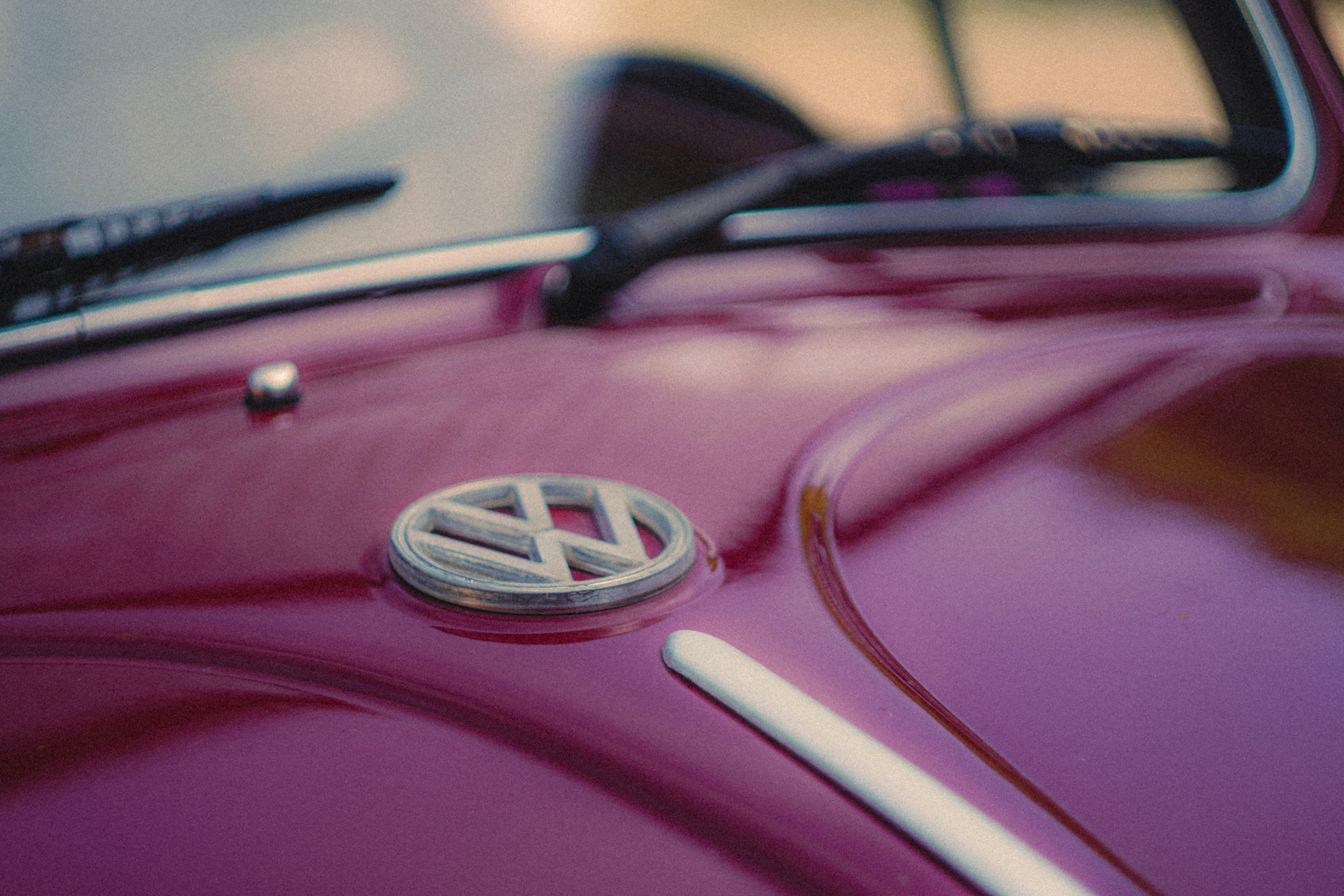 Nahaufnahme eines Volkswagen-Emblems auf einem roten Auto