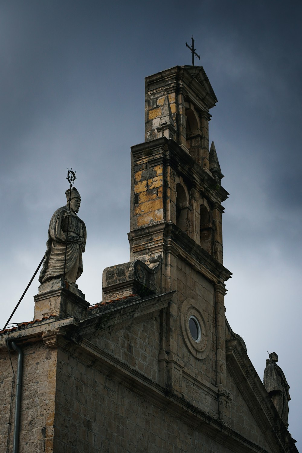 a church steeple with a statue on top of it