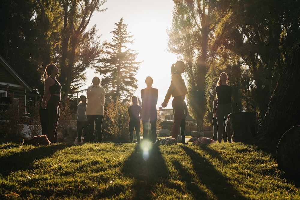 a group of people standing on top of a lush green field