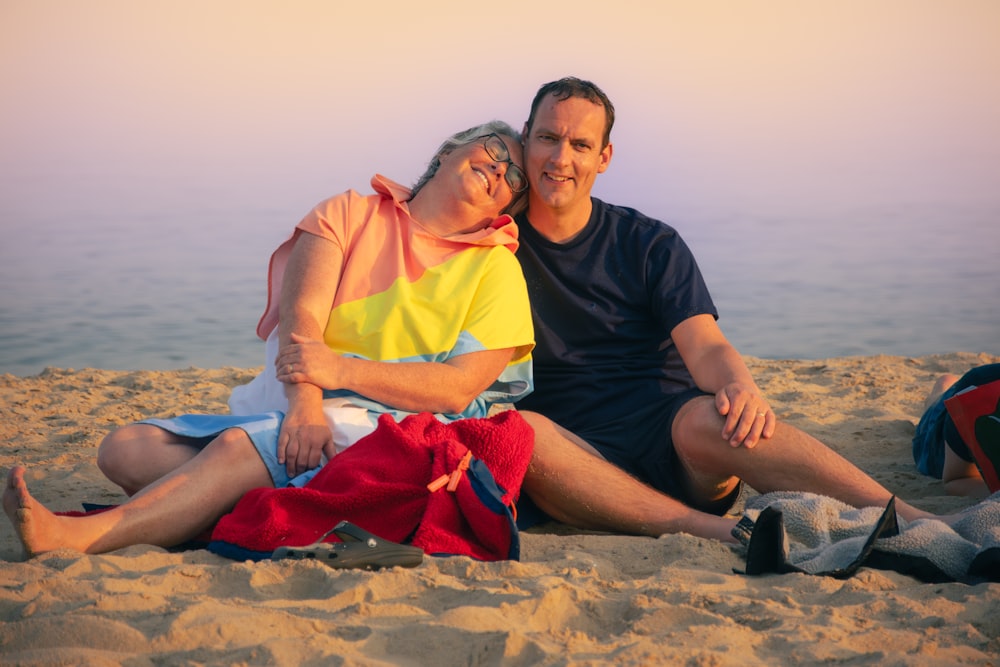 a man and a woman sitting on a beach