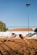 a woman dives to catch a frisbee on the beach