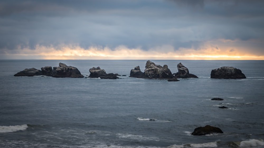 a group of rocks sitting on top of a body of water