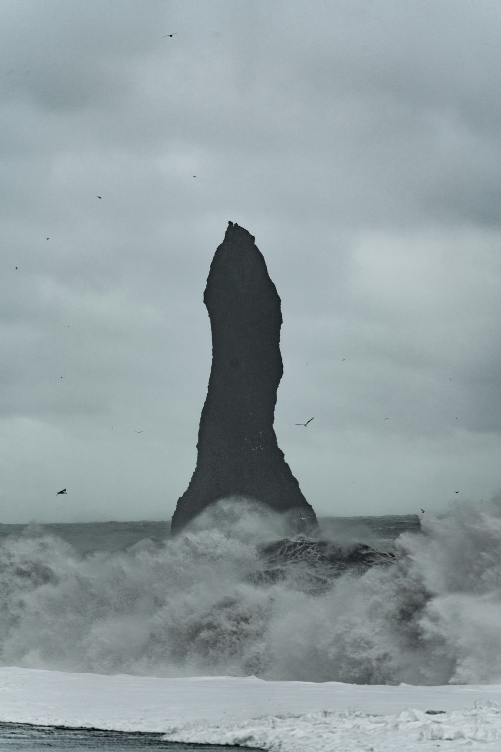 a large rock sticking out of the ocean