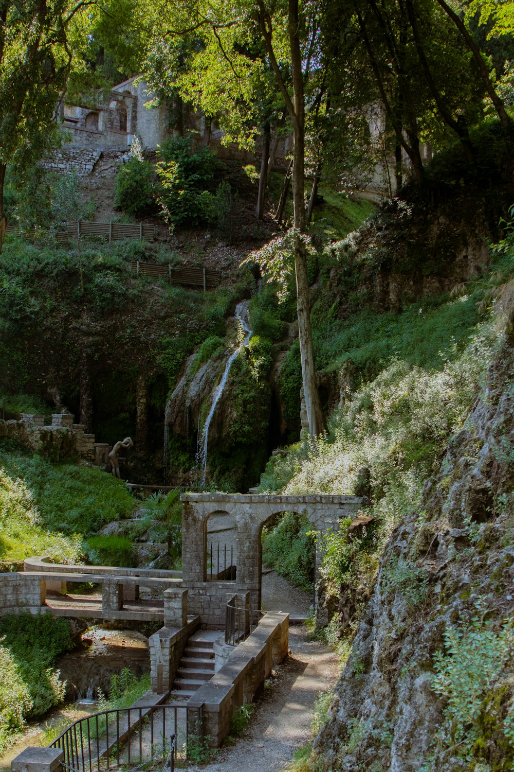 a stone building with a waterfall in the background