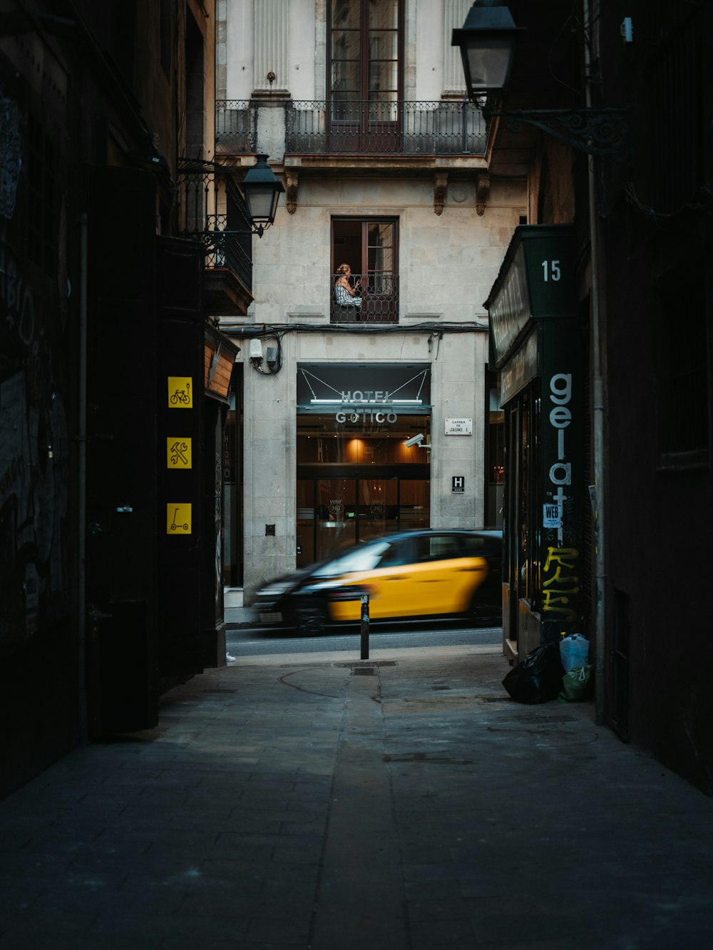 a car driving down a street next to a tall building