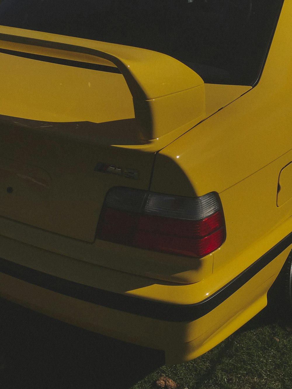 a close up of a yellow car parked on the grass