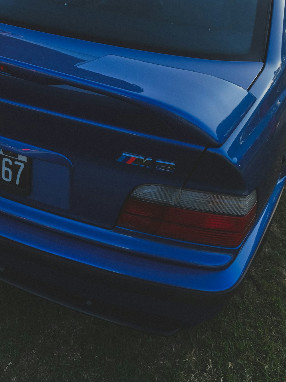Une voiture bleue garée dans un champ herbeux