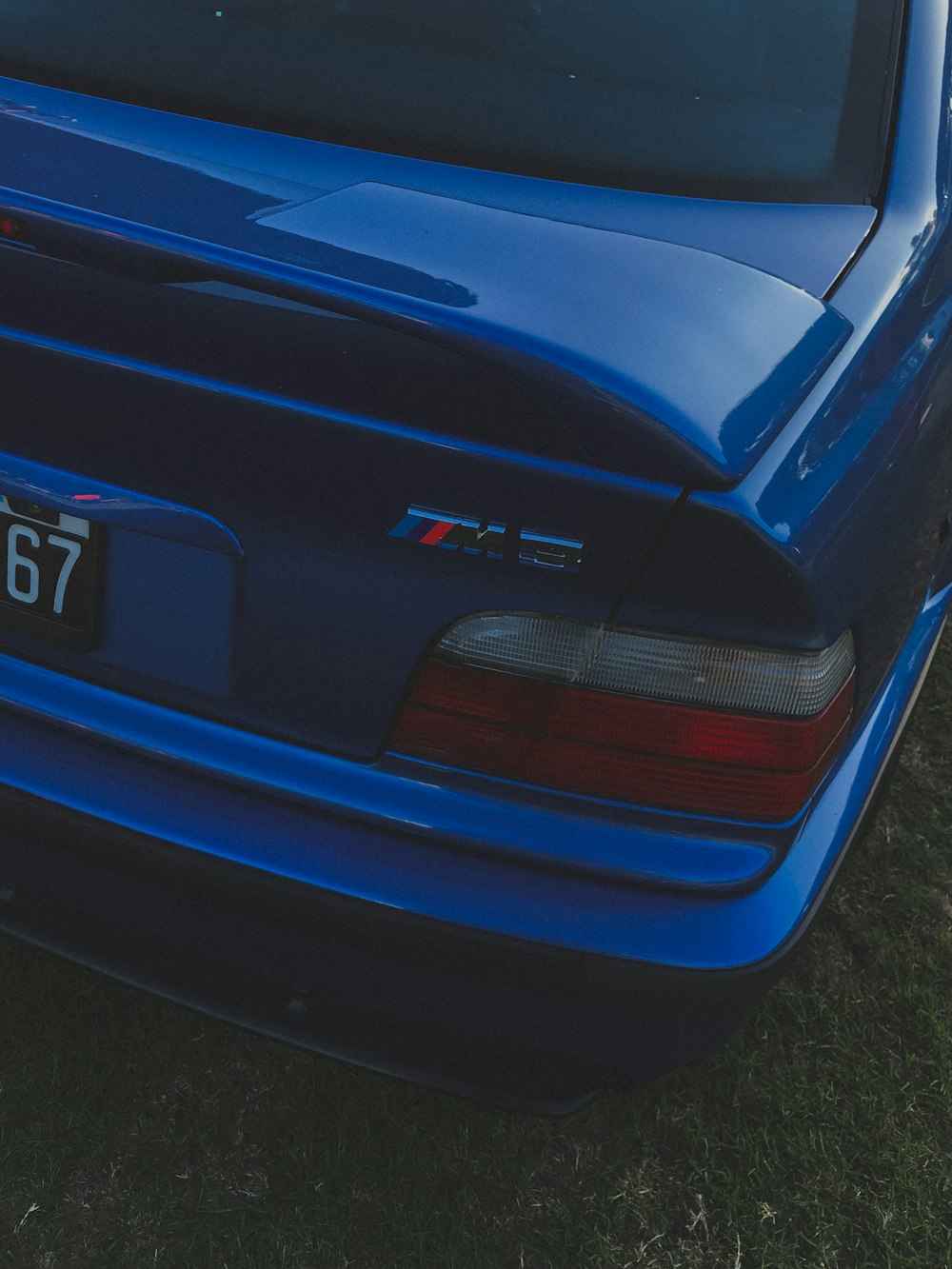 a blue car parked in a grassy field