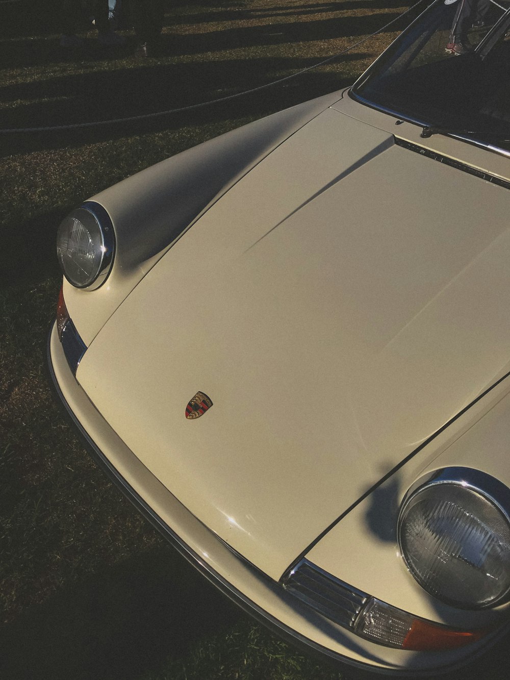 a white car parked on top of a grass covered field