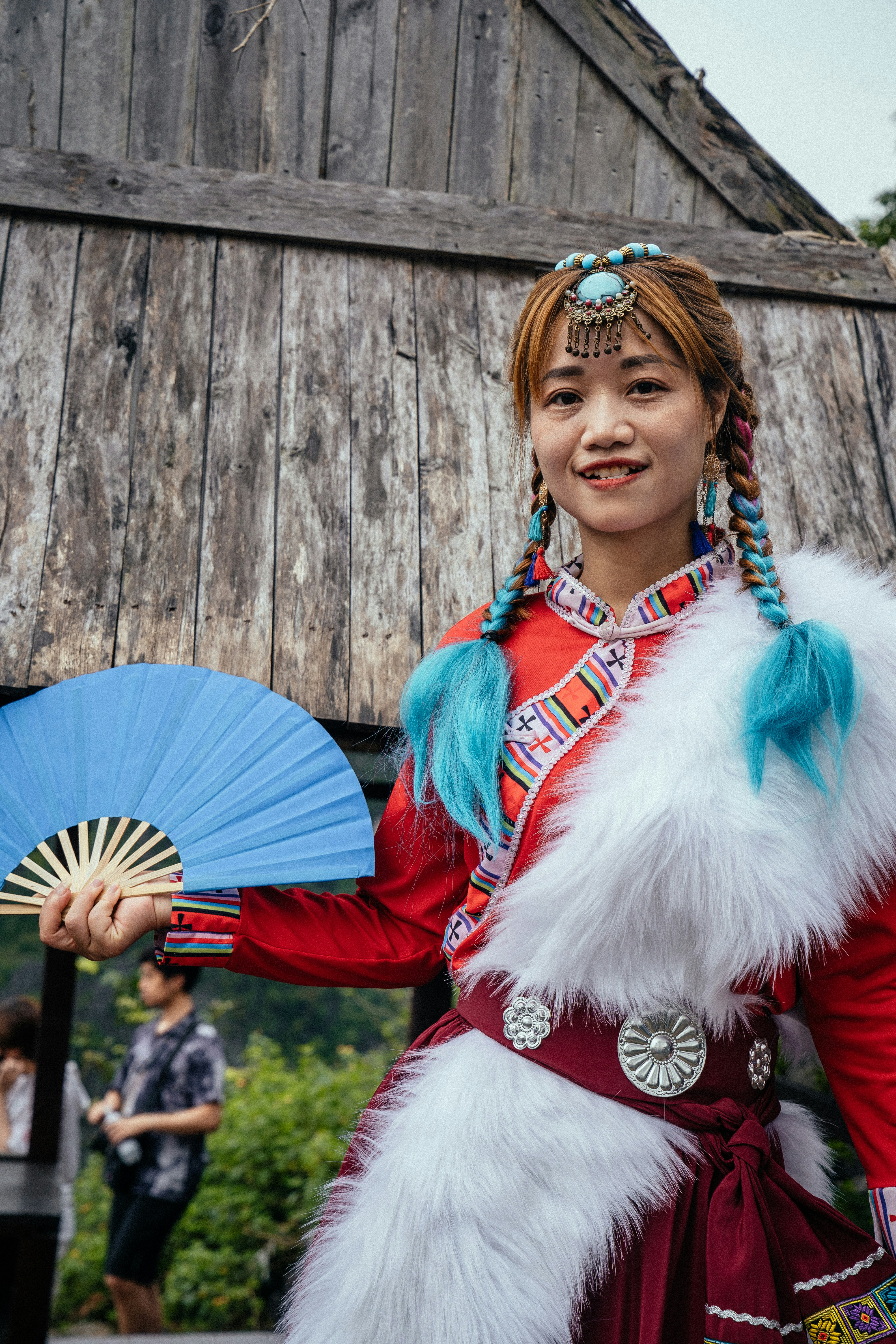 Una mujer disfrazada sosteniendo un abanico azul