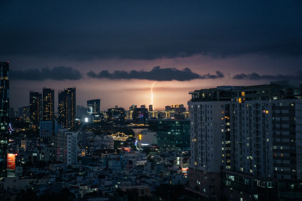 uma vista de uma cidade à noite de um arranha-céus