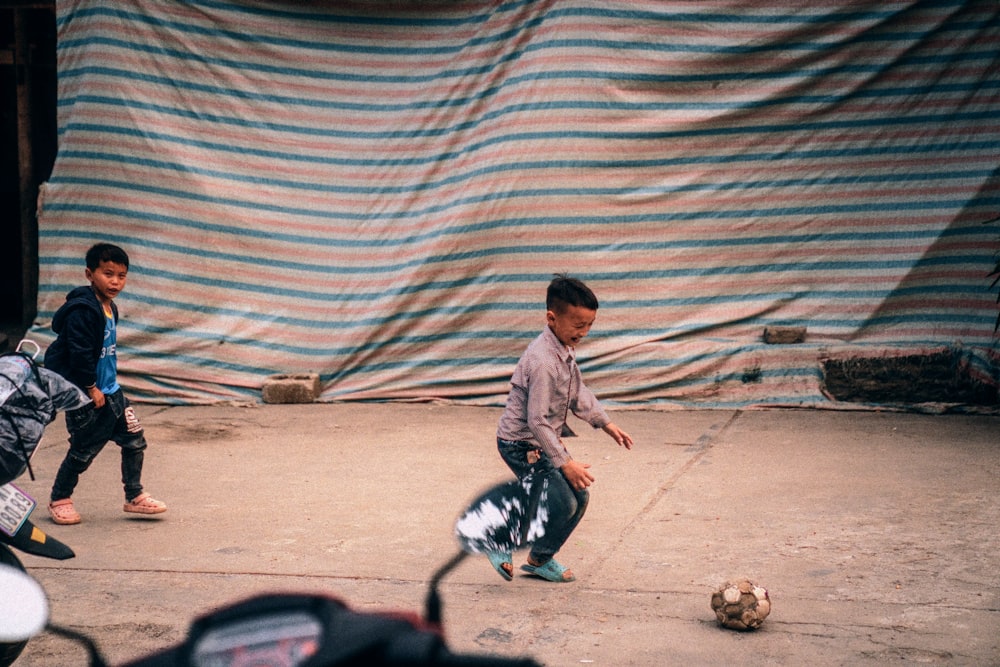 two young boys playing with a soccer ball