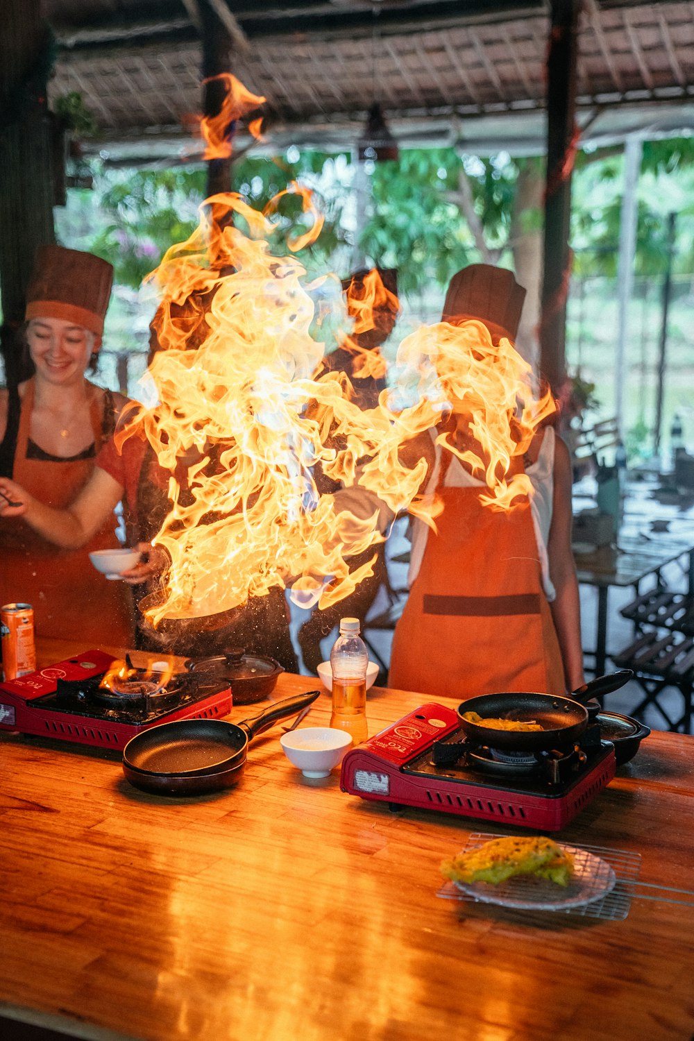 a group of people standing around a table covered in fire