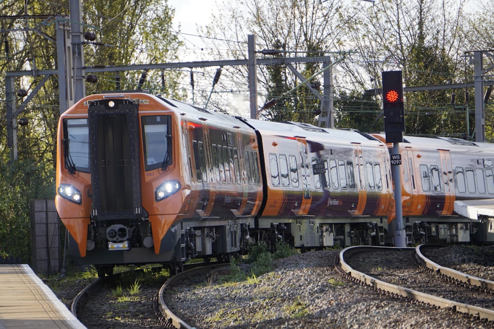 an orange and white train traveling down train tracks