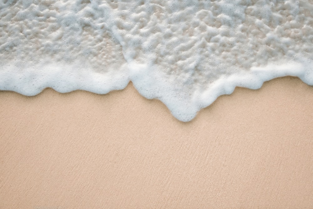 a sandy beach with waves coming in and out of the water