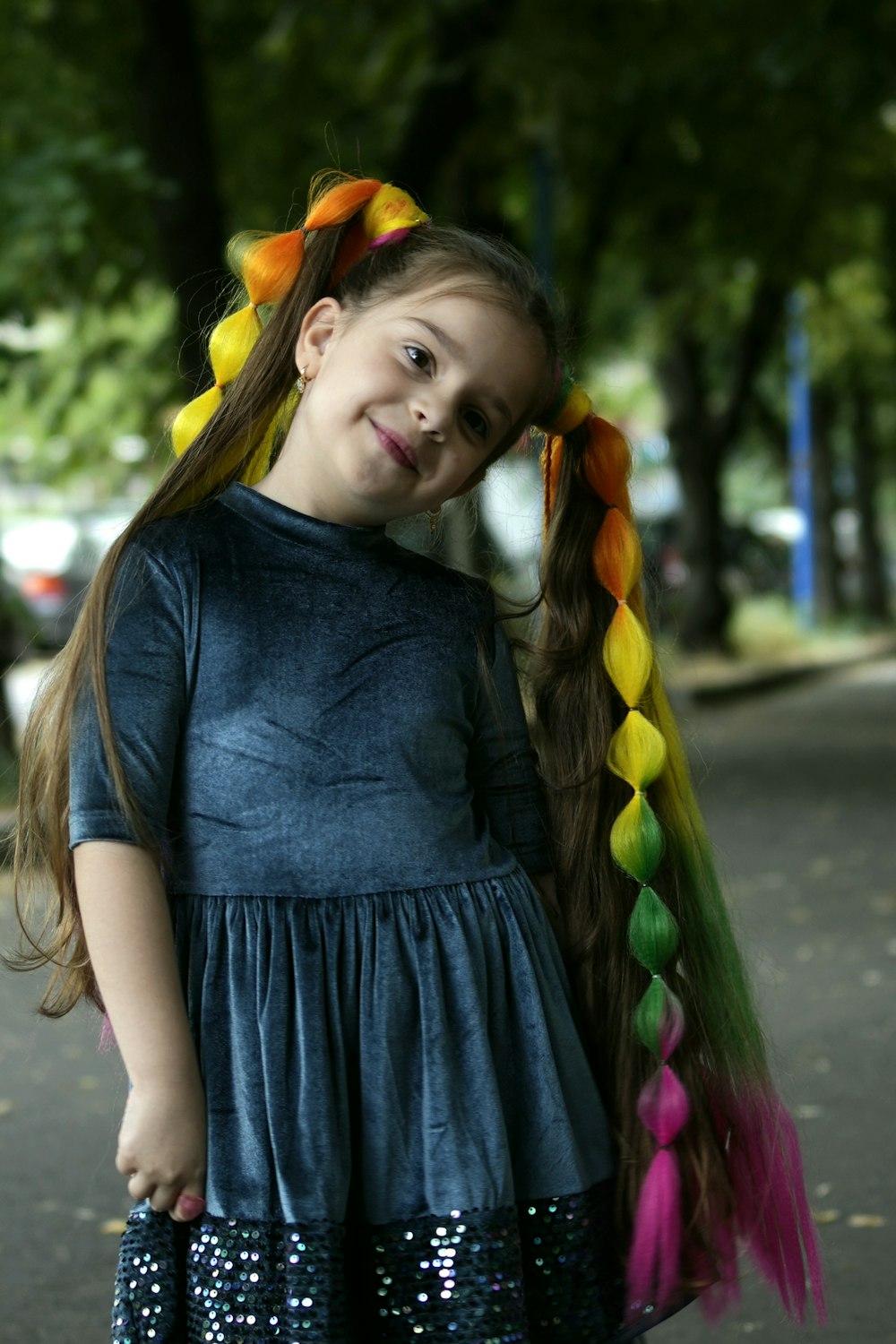 a little girl with long hair wearing a blue dress