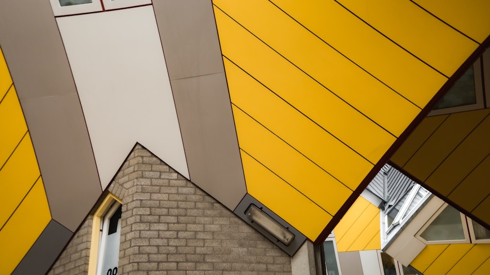 a yellow and grey building with a clock on it's side