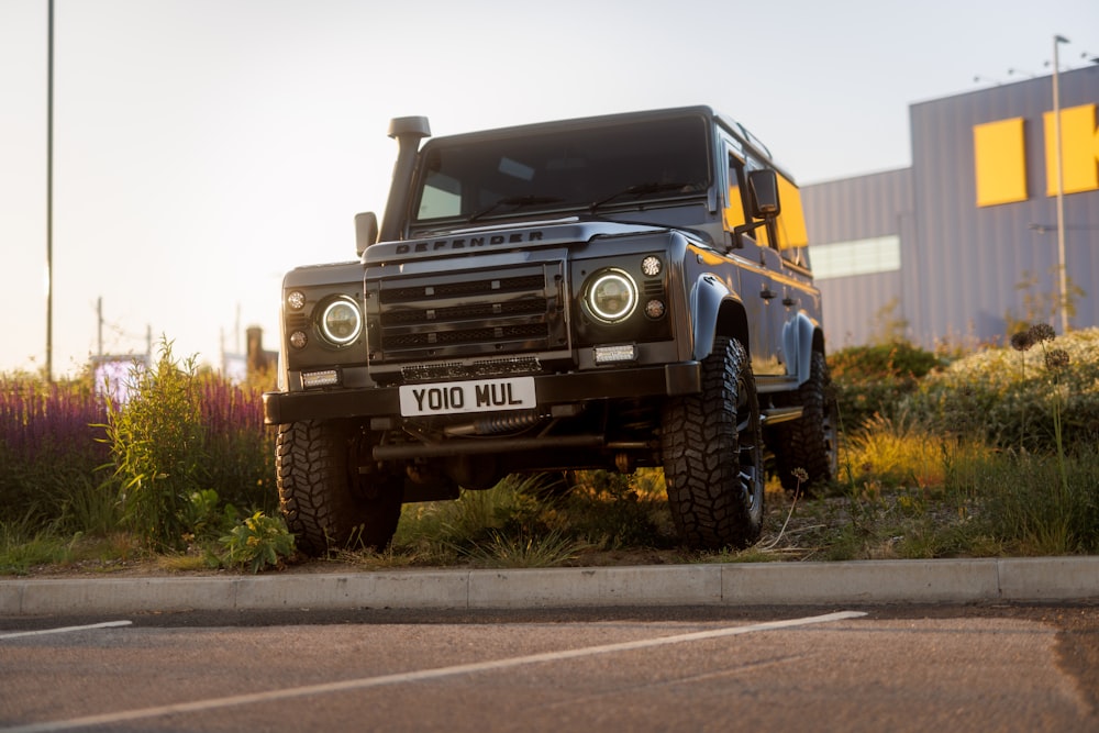 a black land rover parked on the side of the road