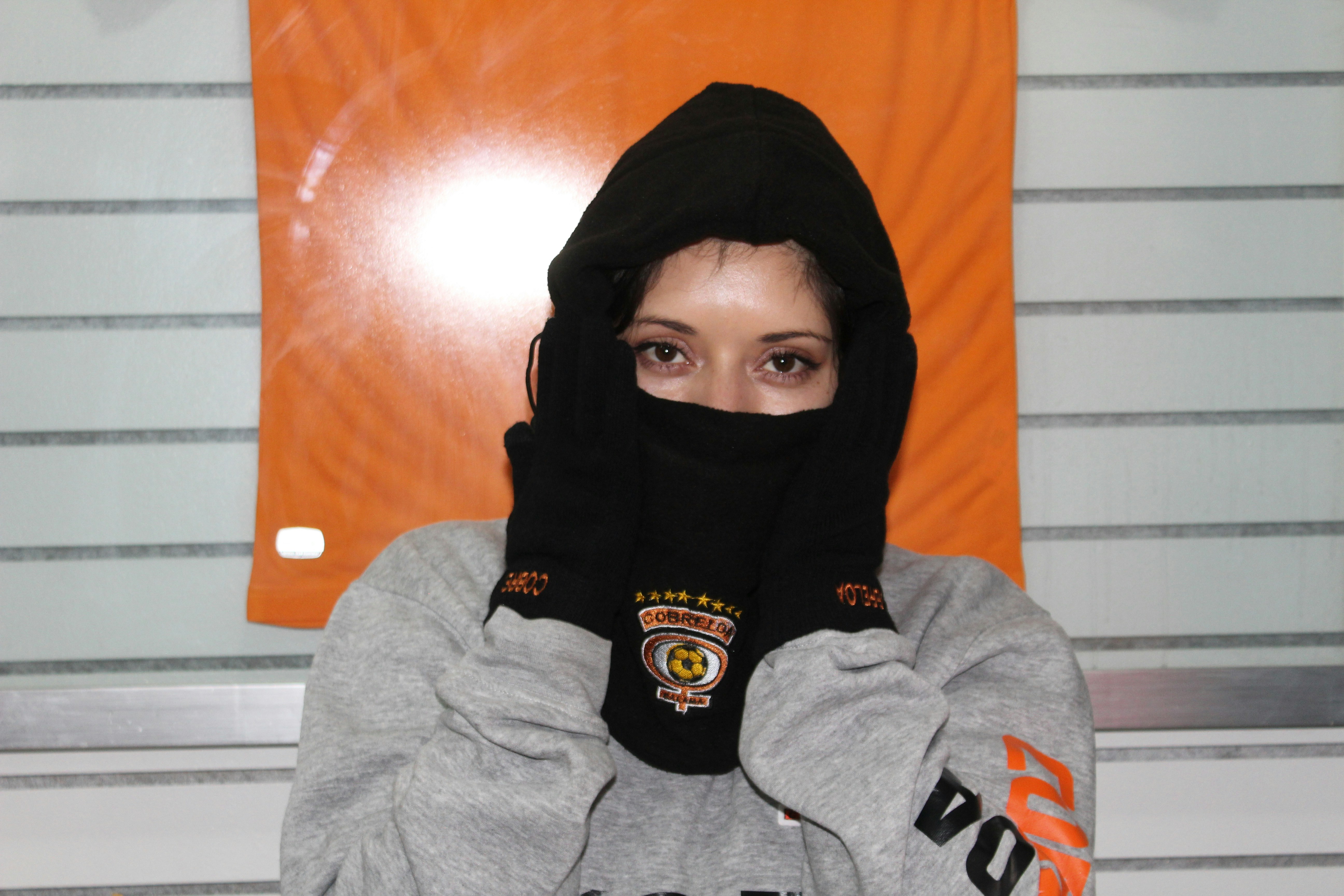 黒いパーカーと黒いスカーフを着た女性