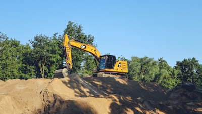 a yellow bulldozer digging through a pile of dirt