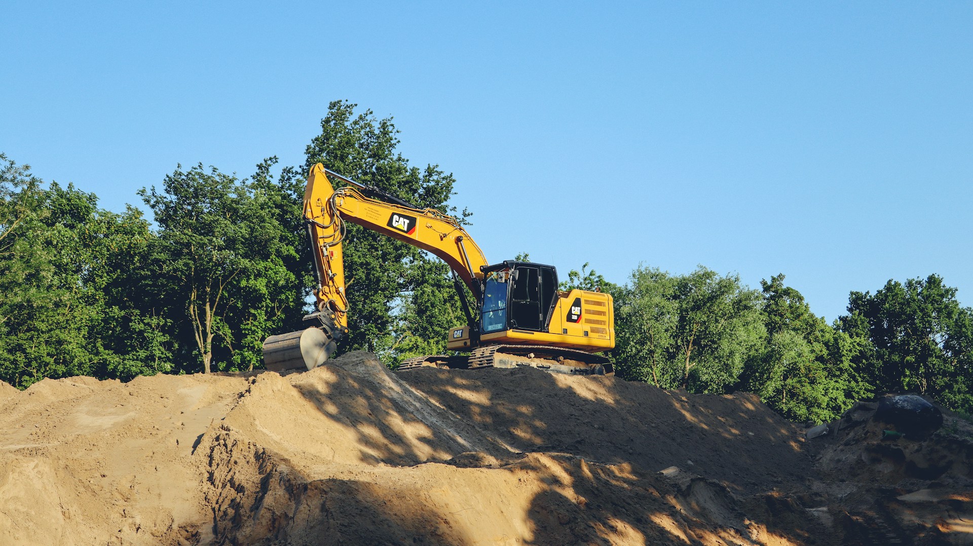 a yellow bulldozer digging through a pile of dirt