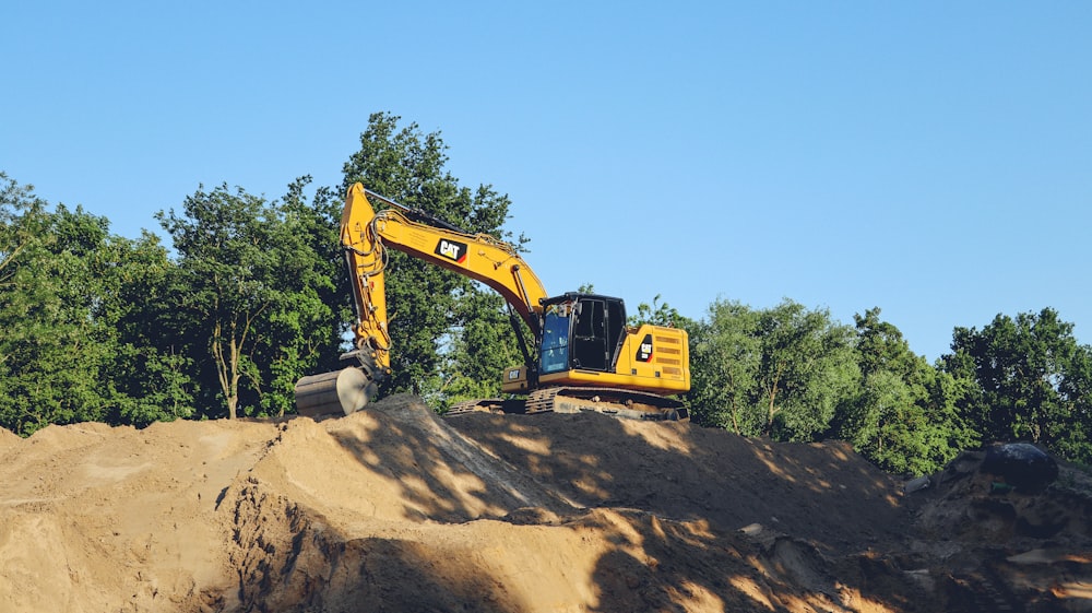 a yellow bulldozer digging through a pile of dirt