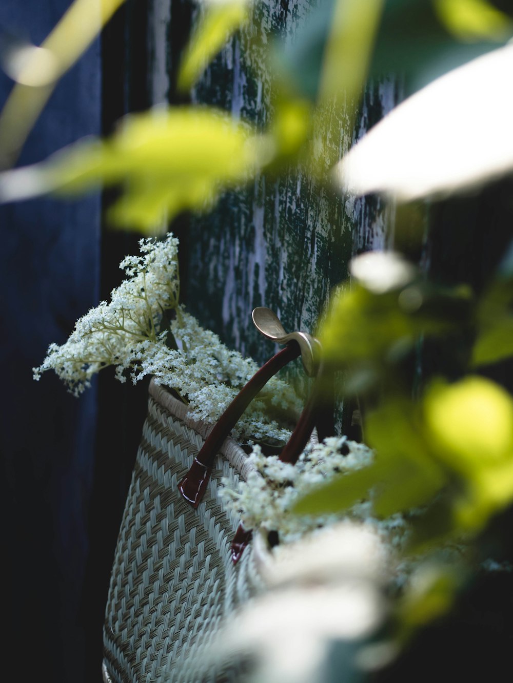 a basket with flowers in it sitting next to a wall