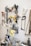A white pegboard with various tools neatly arranged, including power drills, saws, wiring, and clamps. The tools have different colors and shapes, and the board allows for organized storage.