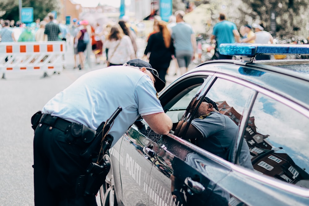 a police officer leaning into a police car