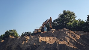 a bulldozer digging through a pile of dirt