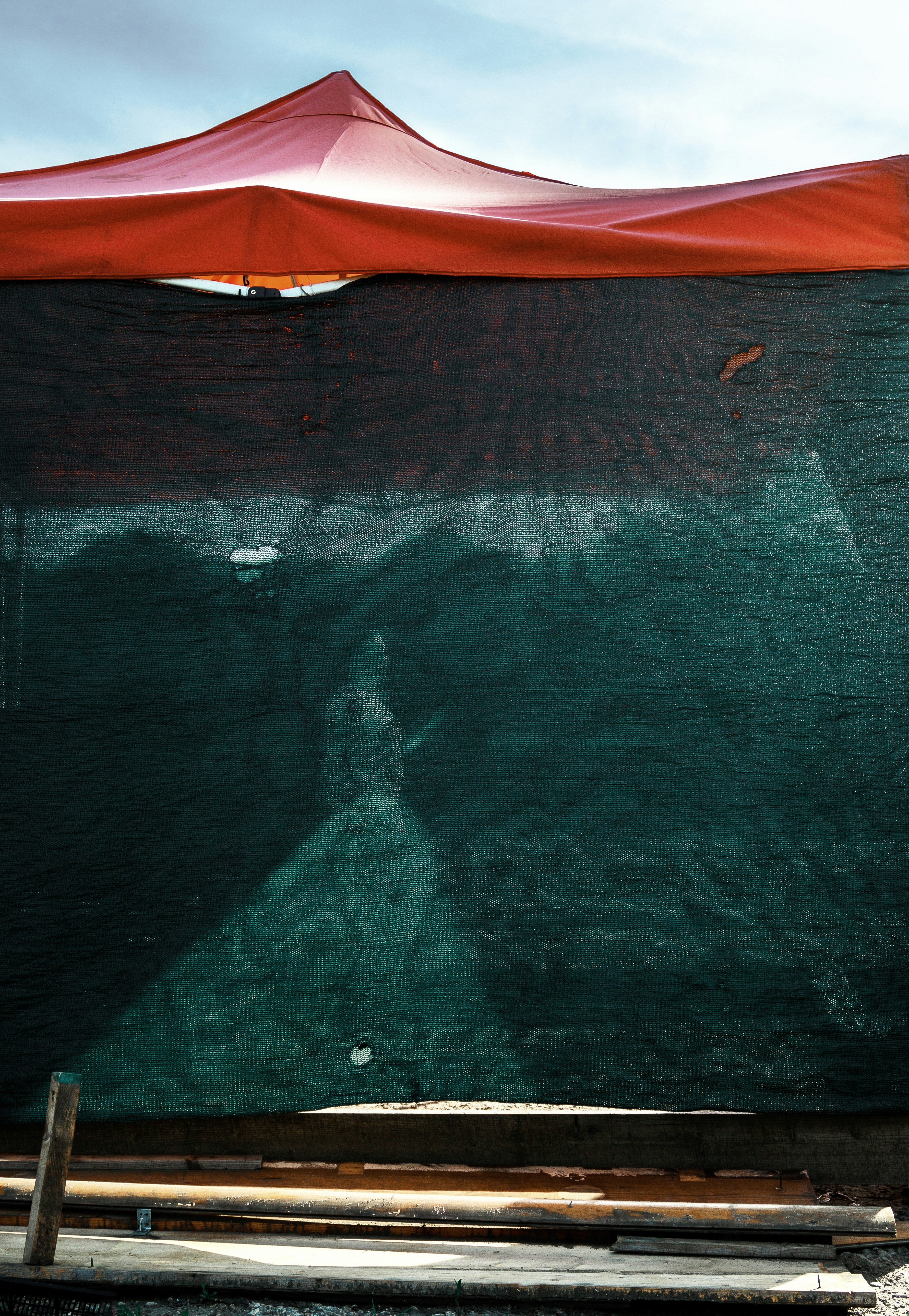 a red umbrella sitting on top of a green board