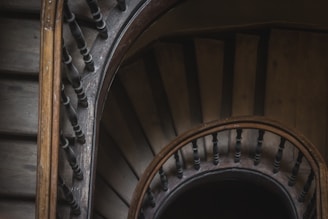 Close-up of a finely crafted wooden staircase with intricate railings inside a luxury home.