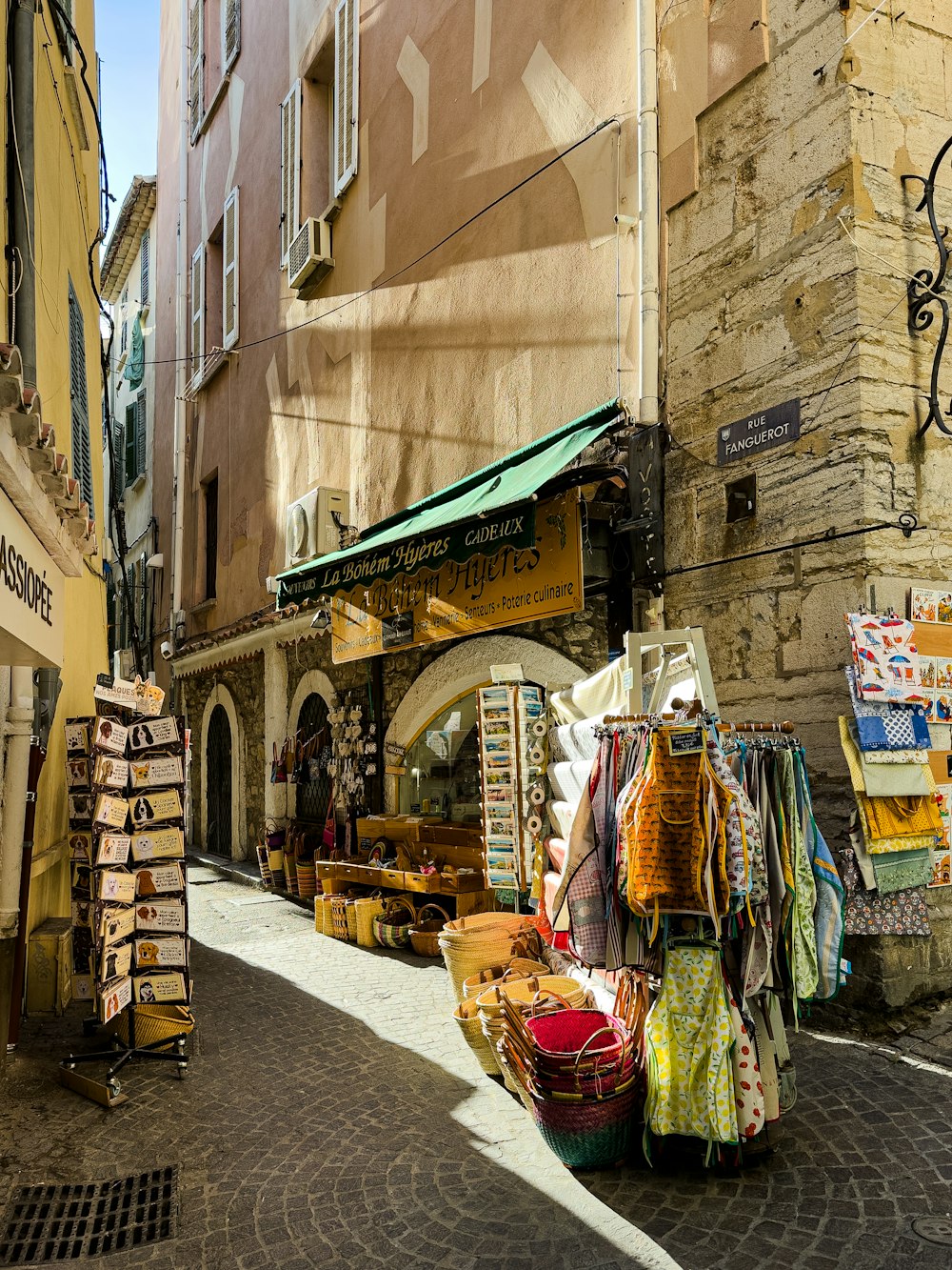 a narrow street with a market in the middle of it