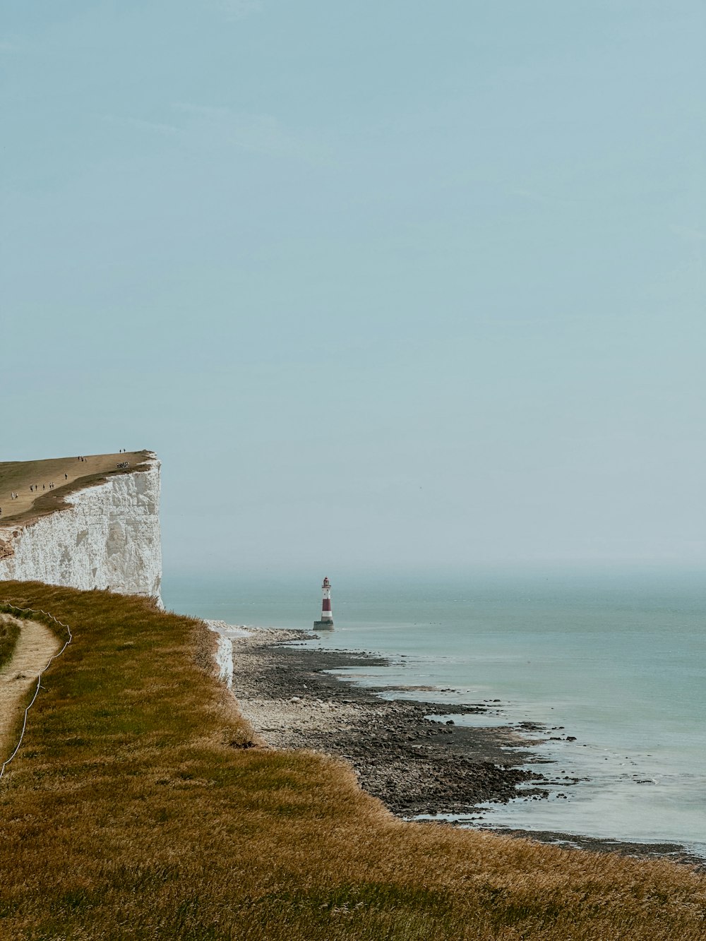 a lighthouse sitting on top of a cliff next to the ocean