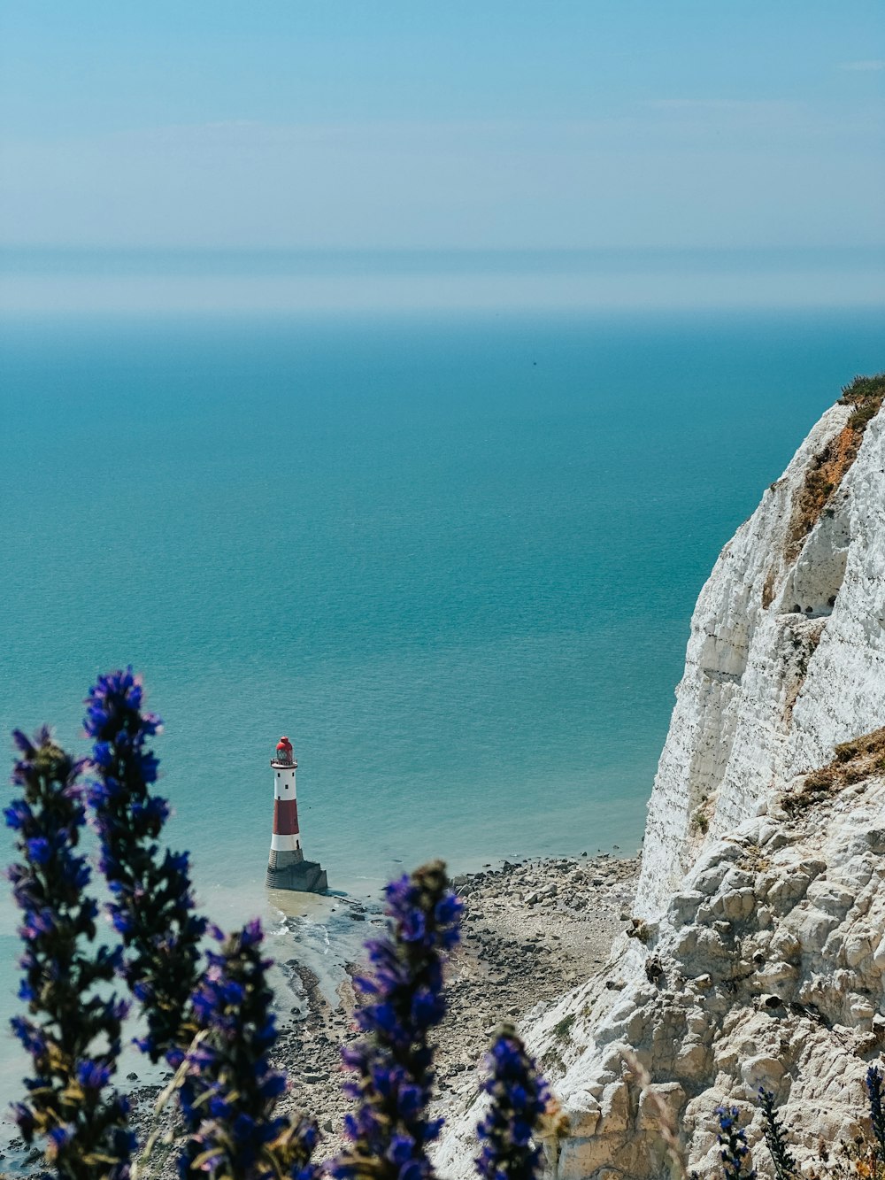 a lighthouse on top of a cliff near the ocean