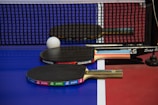 two ping pong paddles resting on a ping pong table
