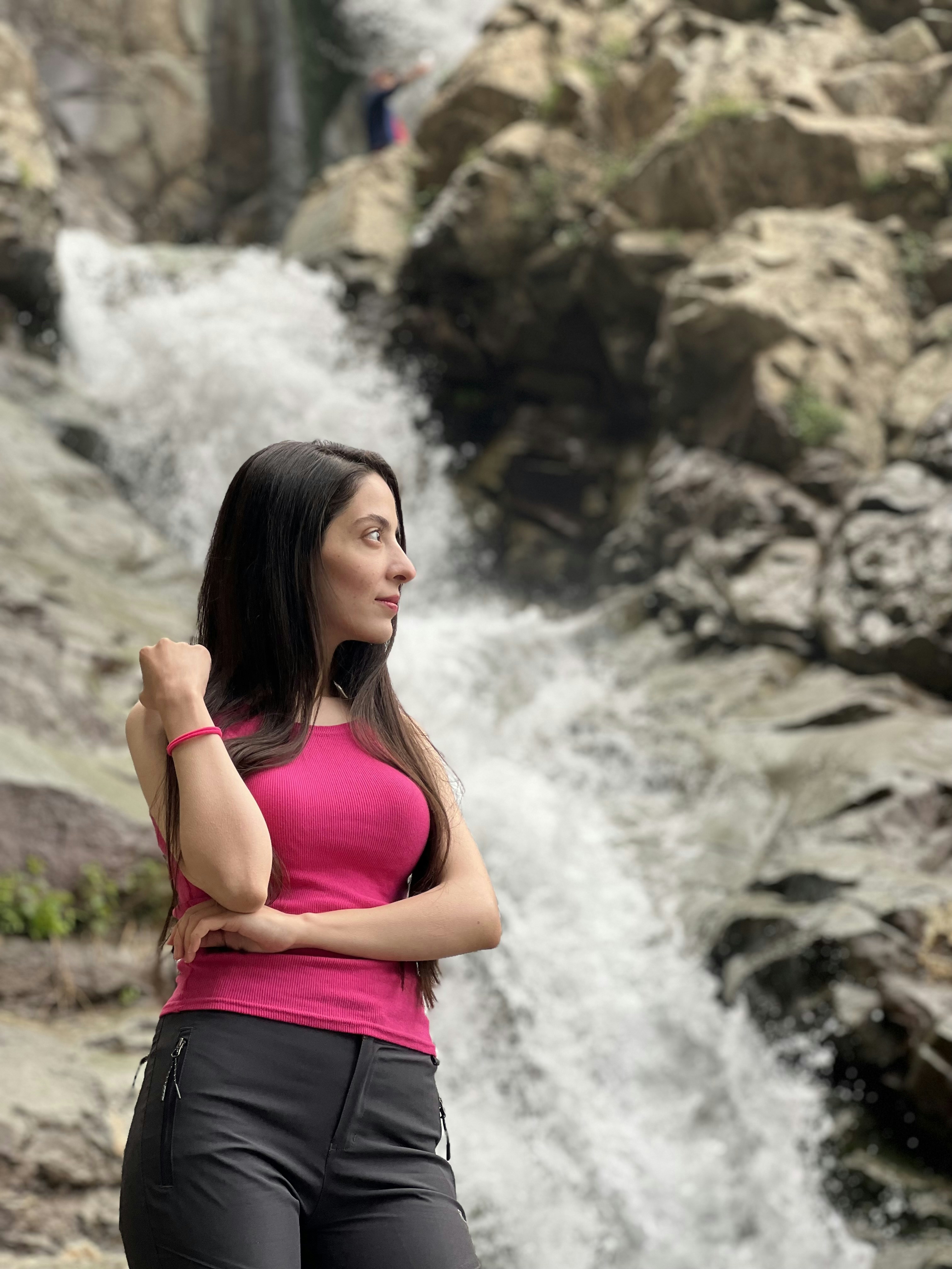 A woman standing in front of a waterfall photo – Free Adult Image on ...