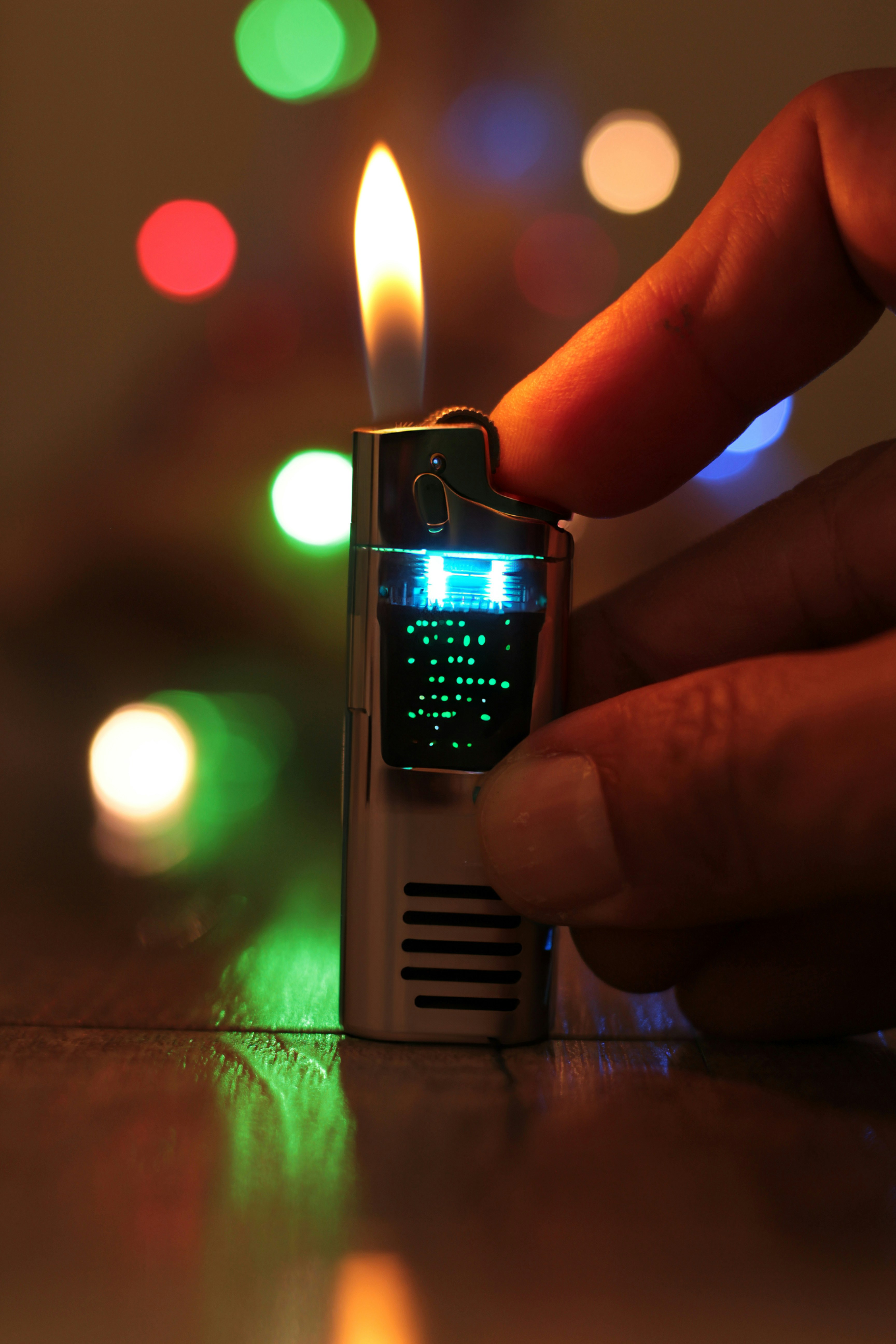 a person lighting a lighter with a green light