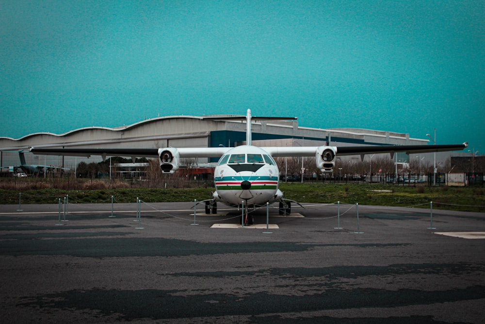 um pequeno avião estacionado em frente a um prédio