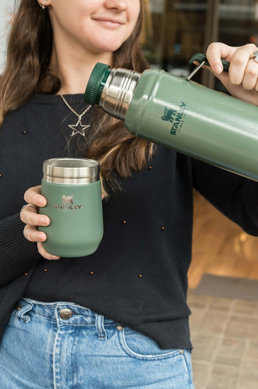 a woman is holding a cup and a water bottle