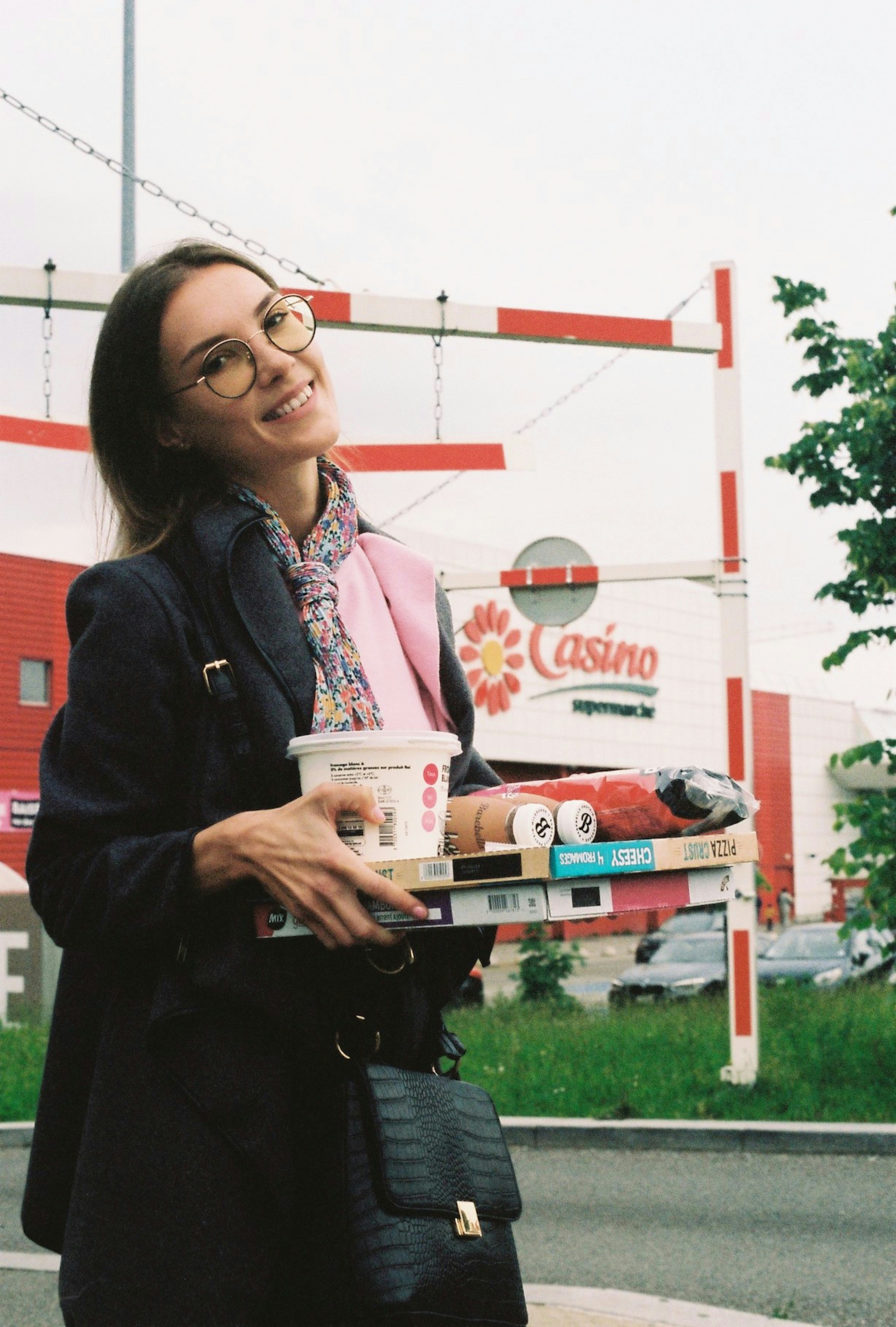 a woman standing on the side of a road holding a cup of coffee