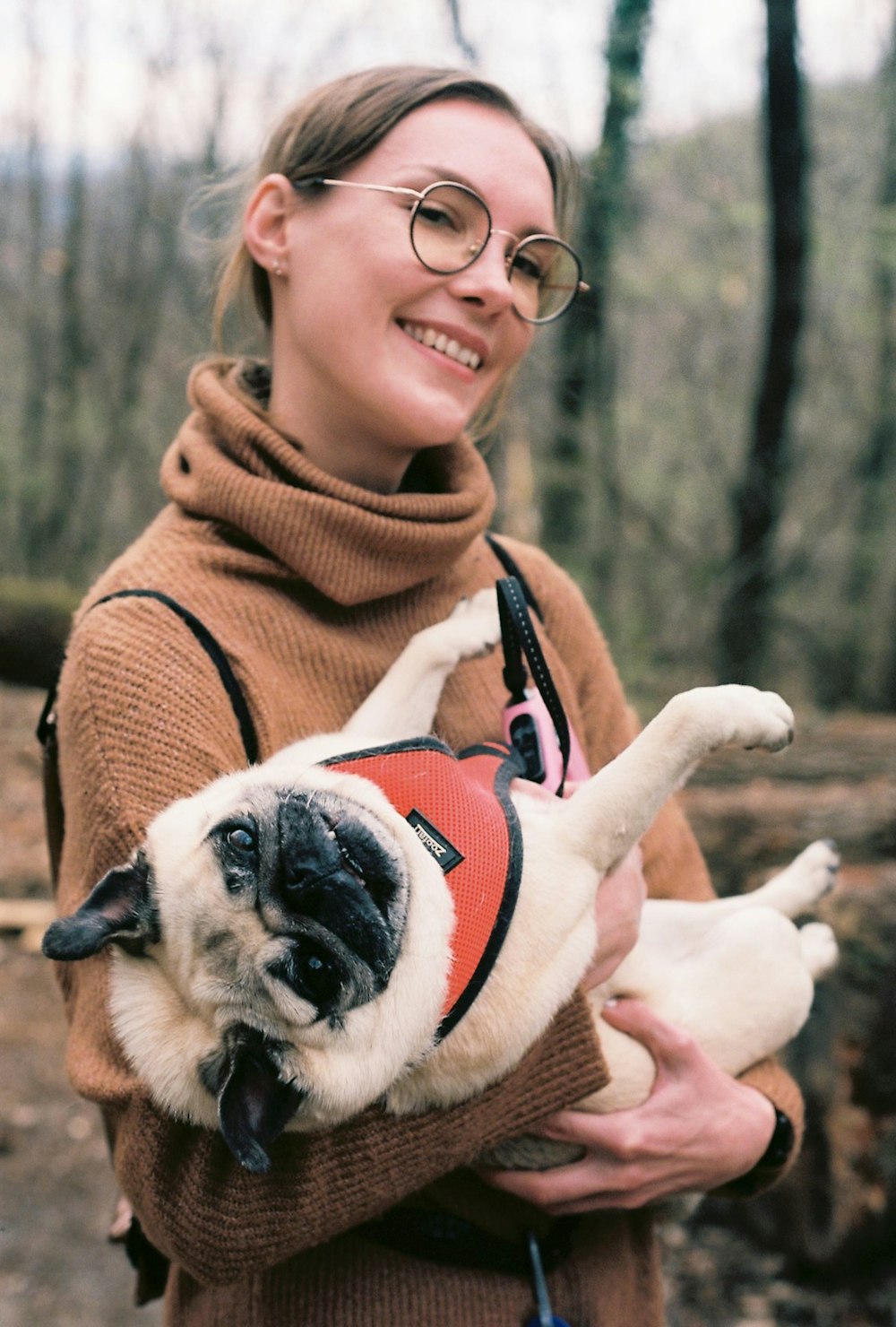 a woman holding a small dog in her arms