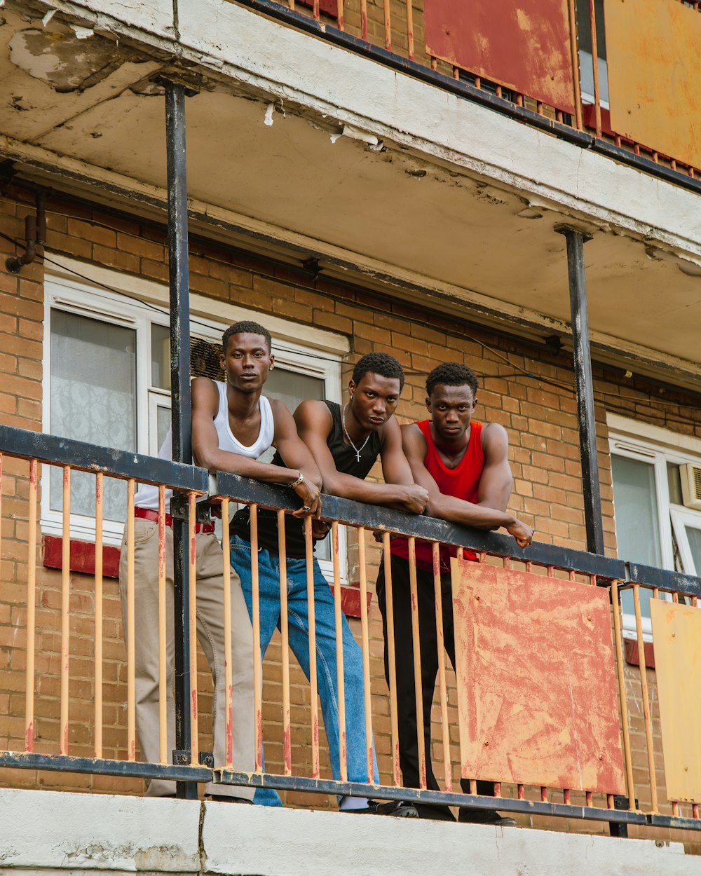 three men standing on a balcony of a building