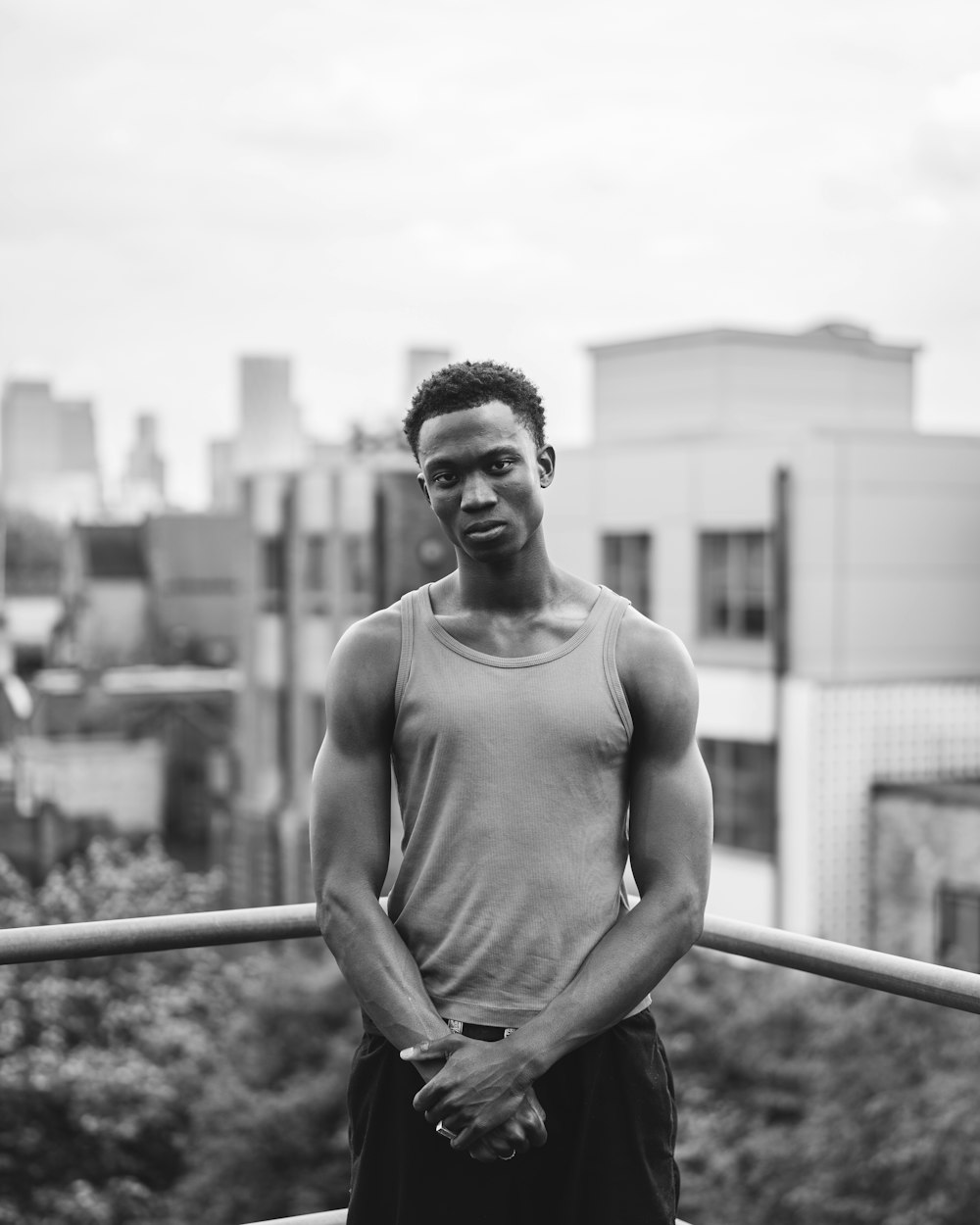 a black and white photo of a man in a tank top