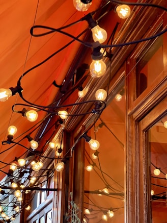Warm glowing string lights draped around a cozy living room window.
