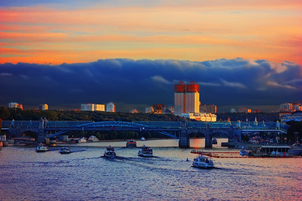 a river with boats in it and a bridge in the background