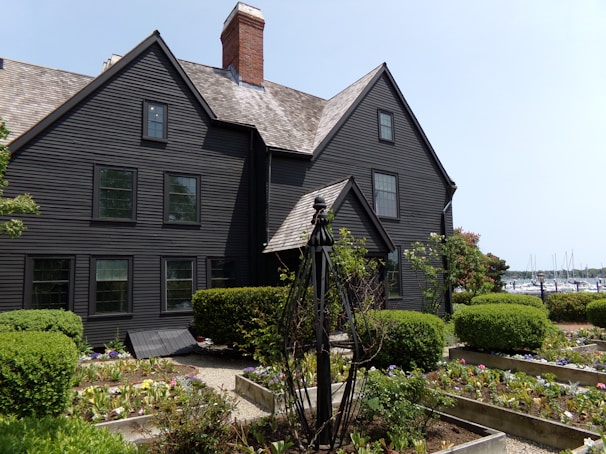 A stately home exterior painted in a rich navy blue with crisp white trim under a clear sky.
