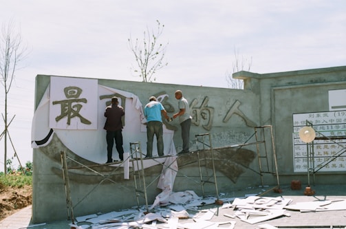 A team of painters working on a large wall.