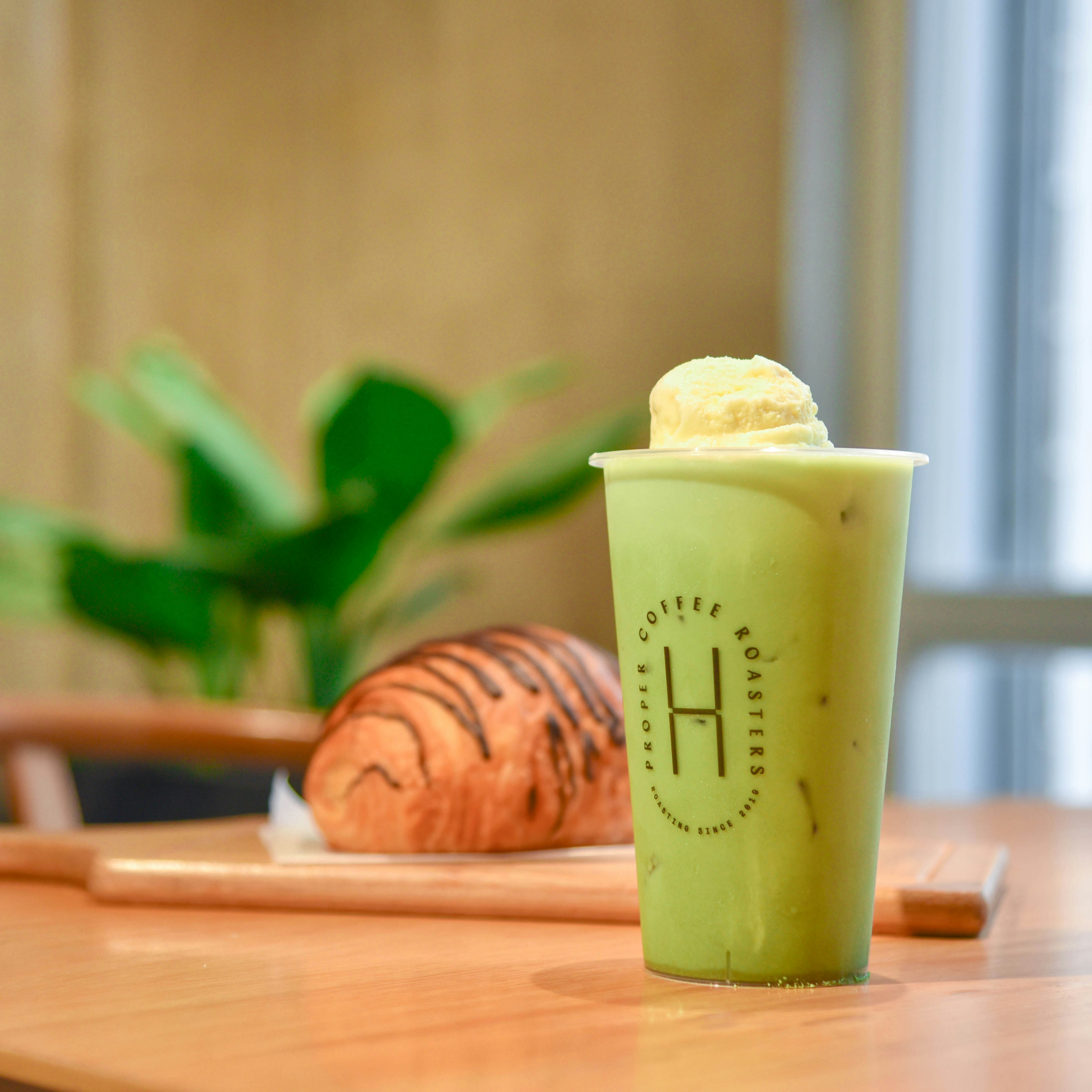 a green drink sitting on top of a wooden table